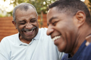 senior man and his adult son laughing together outdoors, gratitude