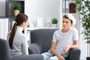 young female therapist working with teenager in office