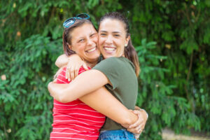 portrait of two young beautiful lesbian smiling girls hug each o