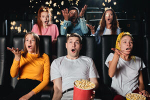 Teens having fun while watching a movie at a movie theater