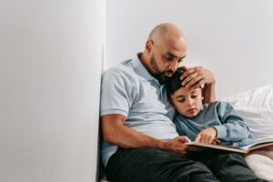 Dad and child cuddling and reading a book