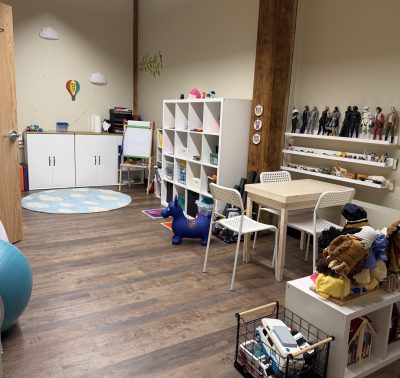 Playroom for child therapy that shows toys, action figures, puppets and other therapy elements for kids.